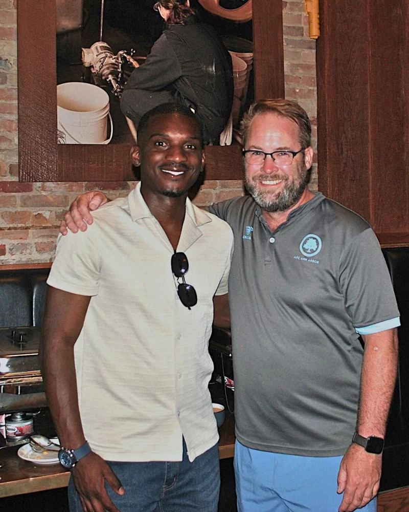 Ahinga Selemani with an AFC Ann Arbor colleague during his transition into football operations